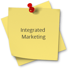 A yellow post it note with the words integrated marketing on top of it.
